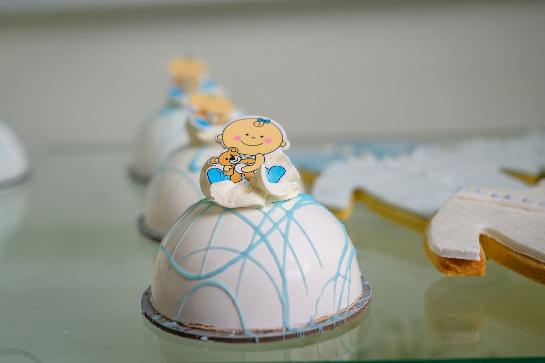 A white dome cake iced in pale blue and decorated for a new baby